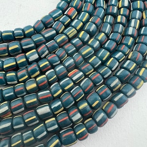 May include: A strand of blue glass beads with white and red stripes. The beads are all the same size and shape, and they are strung together in a continuous line.