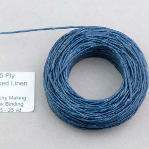 May include: A spool of 5 ply waxed linen thread in a dark blue color. The label reads "5 Ply Waxed Linen" and "Jewelry Making Book Binding RL 5 - 25 yd".
