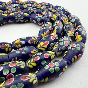 May include: A strand of blue glass beads with white, yellow, red and green painted floral designs.
