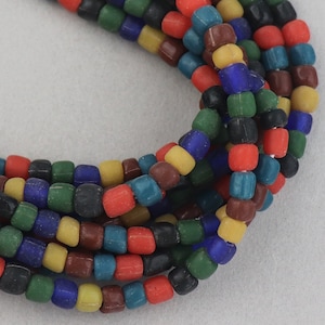 May include: A close-up of a strand of colourful square glass beads. The beads are in shades of red, blue, green, yellow, brown, and black.