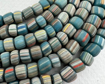 May include: A strand of colourful, striped glass beads. The beads are a mix of blue, white, grey, red, and yellow. The beads are all cylindrical and have a slightly rounded shape.