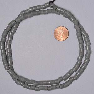 May include: A strand of gray ceramic beads, approximately the size of a US penny.