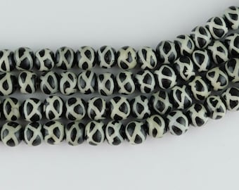 May include: A strand of black and white agate beads with a geometric pattern. The beads are round and have a smooth, polished finish.