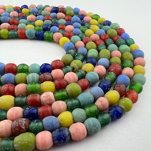May include: A multi-colored strand of glass beads, featuring a variety of colors including blue, green, red, yellow, and pink. The beads are arranged in a circular pattern, creating a visually appealing and colorful display.