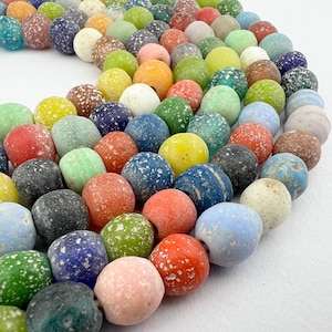 May include: A strand of colourful, speckled glass beads. The beads are round and have a variety of colours, including blue, green, red, yellow, and white.