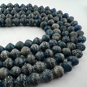 May include: A strand of dark blue glass beads with a speckled white finish. The beads are round and have a slightly irregular shape.