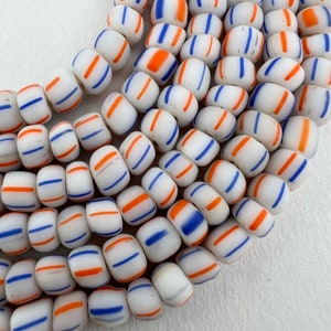 Peut inclure: Un brin de perles de verre blanches avec des rayures bleues et orange. Les perles sont rondes et ont une finition brillante.