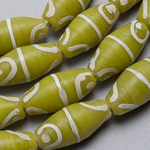 May include: A strand of green and white glass beads with a swirling pattern. The beads are oval shaped and have a glossy finish.