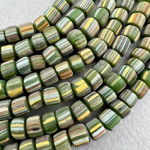 Peut inclure: Un brin de perles de verre rayées de vert, blanc et jaune. Les perles sont cylindriques et ont une forme légèrement irrégulière.