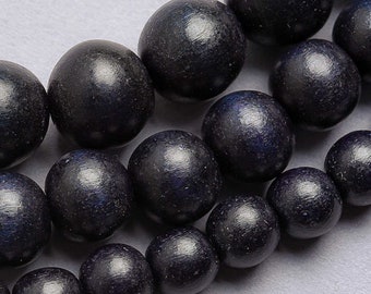 May include: A strand of black wooden beads. The beads are round and smooth, with a slightly glossy finish.