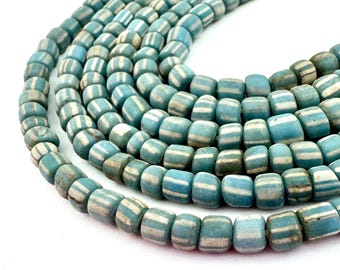 May include: Close-up of a strand of blue and white striped beads. The beads are cylindrical with rounded edges and a matte finish. The color palette includes shades of blue and white, creating a vintage aesthetic. Suitable for jewellery making.