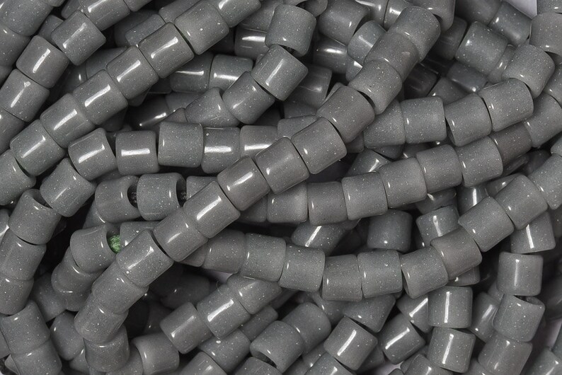 May include: A pile of gray, round, ceramic beads with a speckled texture. The beads are approximately 1/2 inch in diameter.