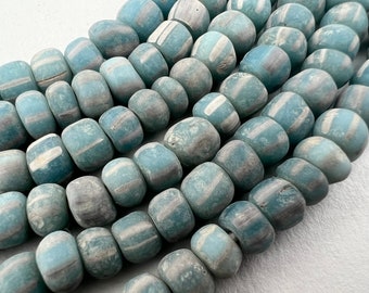 May include: A strand of blue and white glass beads with a mottled, textured surface. The beads are round and have a slightly irregular shape.