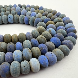 May include: A strand of blue and green speckled ceramic beads. The beads are round and have a rough, textured surface.