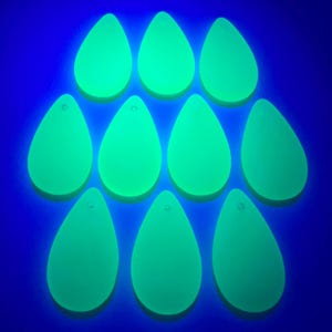 May include: Ten green, teardrop-shaped, glow-in-the-dark, acrylic blanks with a hole at the top.