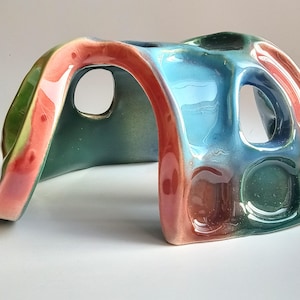 Cave in the aquarium. Colorful ceramic decor. Aquarium decoration.