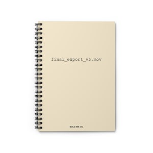 May include: Spiral-bound notebook with a cream-colored cover. The text "final_export_v5.mov" is printed in black near the center. The words "BOLD INK CO." are printed in black at the bottom.