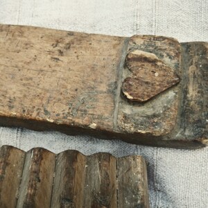 Puede incluir: Un antiguo lavadero de madera con un dise&ntilde;o en forma de coraz&oacute;n tallado en la parte superior. El lavadero est&aacute; hecho de madera toscamente labrada y tiene un aspecto desgastado y r&uacute;stico.