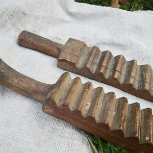 Puede incluir: Dos lavaderos de ropa de madera antiguos con una superficie texturizada y una serie de crestas elevadas. Los lavaderos son de madera marr&oacute;n claro y tienen un aspecto desgastado y r&uacute;stico.