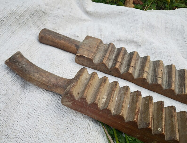 Puede incluir: Dos lavaderos de ropa de madera antiguos con una superficie texturizada y una serie de crestas elevadas. Los lavaderos son de madera marr&oacute;n claro y tienen un aspecto desgastado y r&uacute;stico.