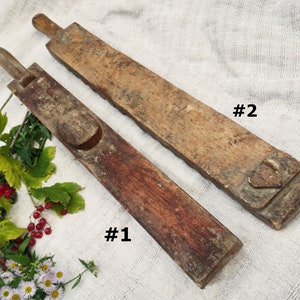 Puede incluir: Dos herramientas de madera antiguas, etiquetadas como #1 y #2, con dise&ntilde;os tallados &uacute;nicos. Las herramientas est&aacute;n hechas de madera marr&oacute;n oscura y marr&oacute;n claro y tienen un aspecto r&uacute;stico.