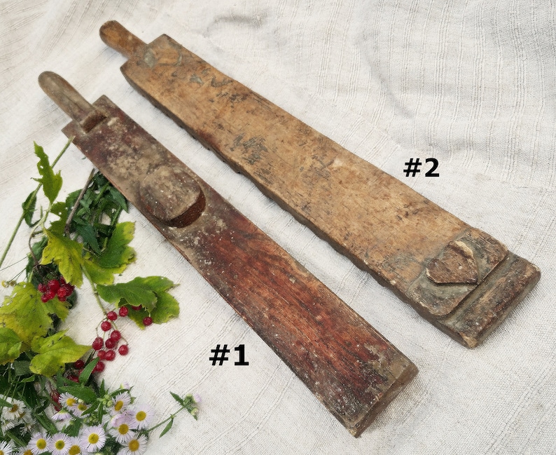 Puede incluir: Dos herramientas de madera antiguas, etiquetadas como #1 y #2, con dise&ntilde;os tallados &uacute;nicos. Las herramientas est&aacute;n hechas de madera marr&oacute;n oscura y marr&oacute;n claro y tienen un aspecto r&uacute;stico.
