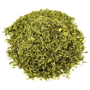 May include: A pile of dried green herbs, likely dill, on a white background.
