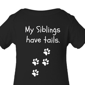 May include: Black baby onesie with white text that reads "My Siblings have tails." and four white paw prints.