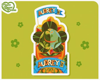 Peut inclure: Un autocollant représentant une illustration stylisée d'une plante avec le texte "Audrey II" sur une bannière bleue. La plante est verte, orange et marron avec un contour blanc.