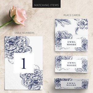 K&ouml;nnte beinhalten: Ein Set druckbarer Hochzeitspapeterie mit einem floralen Design mit blauen Pfingstrosen. Das Set enth&auml;lt eine Tischnummernkarte mit der Nummer "1", eine Platzkarte mit dem Namen "Emma Moore" und eine passende Platzkarte mit dem gleichen Design.