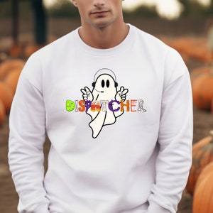 May include: White sweatshirt with a ghost wearing headphones and the word "DISPATCHER" spelled out in Halloween-themed letters.
