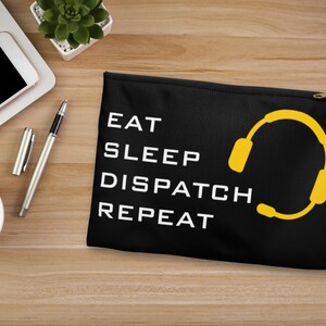May include: Black zippered pouch with the text "Eat Sleep Dispatch Repeat" in white and a yellow headset graphic.
