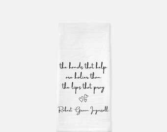 May include: White kitchen towel with a black quote that reads "the hands that help are holier than the lips that pray" and the name "Robert Green Ingersoll" below the quote.
