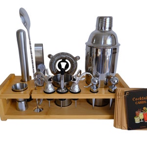 May include: A bamboo bar tool set with a stainless steel cocktail shaker, jigger, muddler, strainer, and other bar tools. The set also includes a set of cocktail recipe cards.