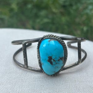 Vintage unmarked Sterling Navajo cuff bracelet with decorative stamping and large polished turquoise cabochon