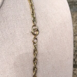 May include: A gold chain necklace with a lobster clasp closure.