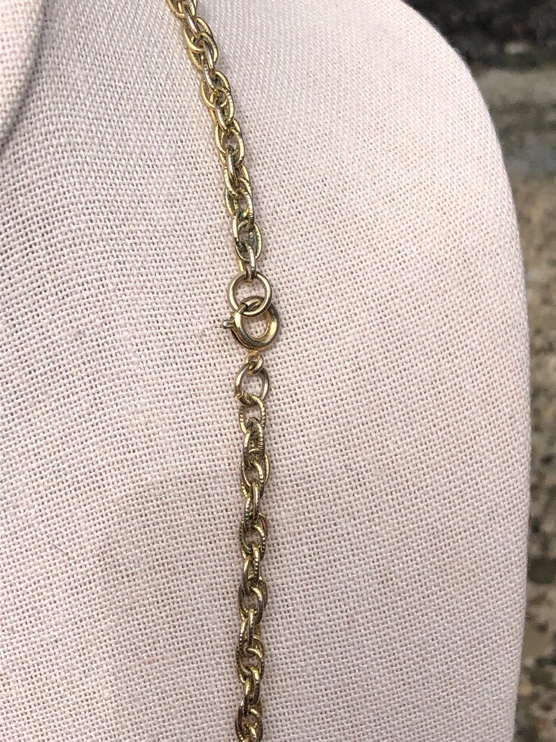 May include: A gold chain necklace with a lobster clasp closure.