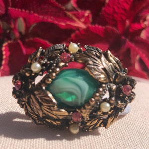 Vintage ornate floral motif heavy well constructed brooch with rhinestones faux pearls and swirled green glass center cabochon