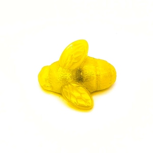 May include: A yellow plastic bee figurine with detailed wings and a textured body.