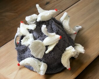 Tea cosy with cliff with doves