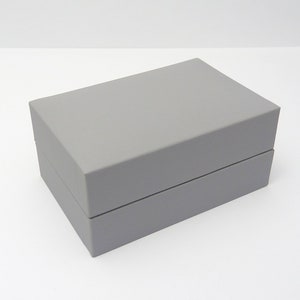 a closed cufflink presentation case finished in grey with a slightly padded lid