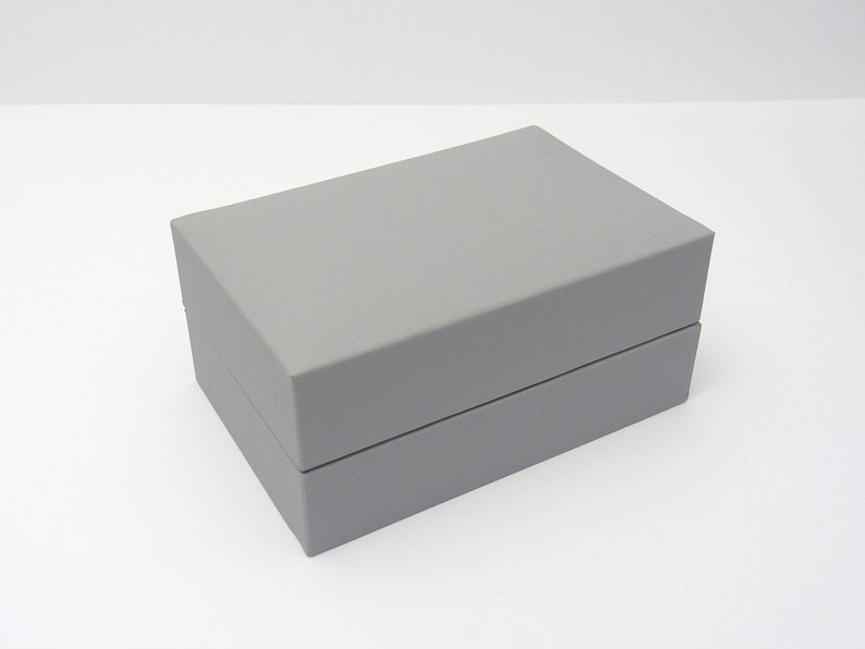 a closed cufflink presentation case finished in grey with a slightly padded lid