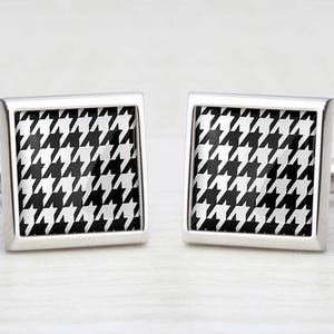 May include: A pair of silver cufflinks with a black and white houndstooth pattern.