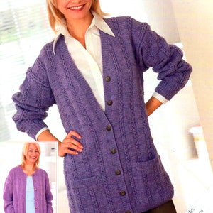 May include: A purple knitted cardigan with a button-up front and two pockets. The cardigan is shown on a model wearing a white shirt and black trousers. The text "Sirdar" is visible at the bottom of the image. The text "Includes Larger Sizes" is visible in the bottom right corner of the image.