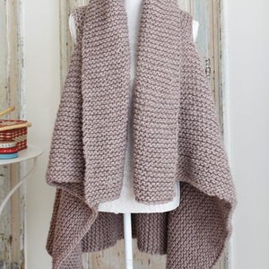 May include: A brown knitted vest with a long, draped collar and a slightly asymmetrical hem.