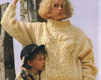 May include: A cream-coloured knitted jumper with a cable knit pattern and a high neck. The jumper is being worn by a person with short blonde hair.