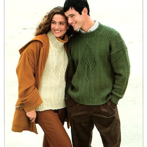 May include: A couple in knitted sweaters and corduroy pants. The woman wears a tan coat over a cream-colored turtleneck sweater. The man wears a green cable-knit sweater and brown corduroy pants. The text "DOUBLE KNITTING" is at the top.