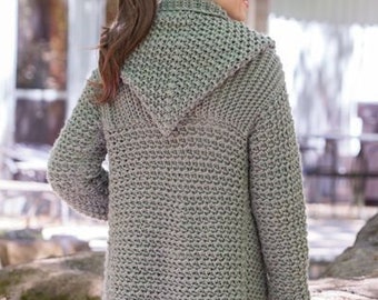 May include: A light grey, hooded cardigan with a textured knit pattern. The long-sleeved sweater has a relaxed fit and a shawl collar. The model is wearing blue jeans. The sweater is a versatile piece for layering, suitable for various outfits.