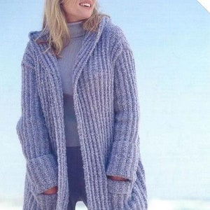 May include: A light blue knitted cardigan with a hood and pockets. The cardigan is open in the front and has a ribbed texture.