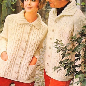 May include: Two cream-colored knitted cardigans with button closures and cable knit patterns. The cardigans have large collars and pockets.
